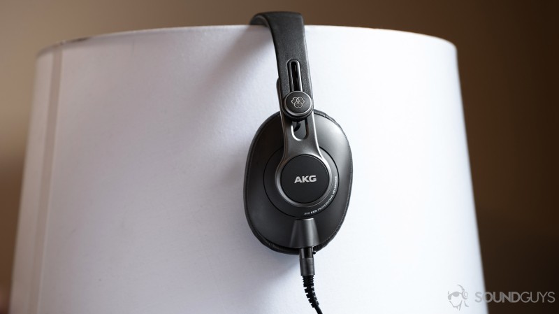 A picture of the AKG K371 wired over-ear headphones in profile on a lampshade.