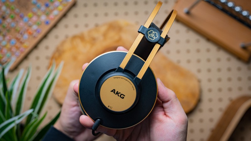 A photo of the AKG K92 held in a hand, with a pegboard backdrop.