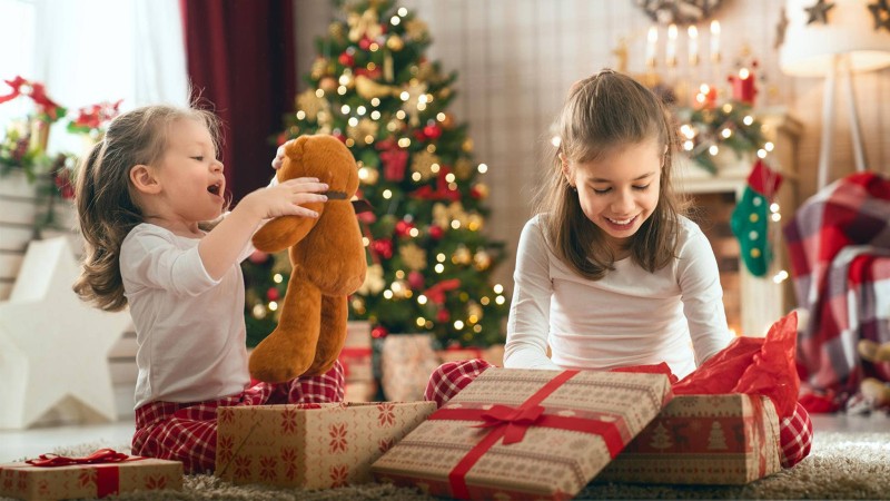 Kinder packen Weihnachtsgeschenke aus